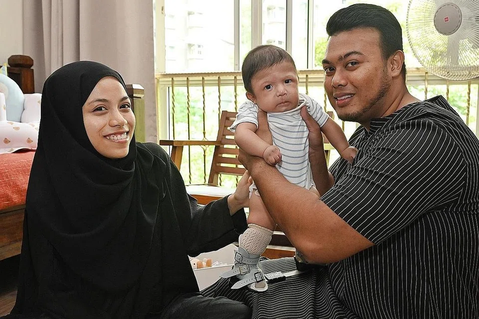 SANGGUP MELAKUKAN APA-APA: Cik Nurul Fateha Abdul Rashid dan Encik Muhammad Nurfahmy Fareed bersama anak mereka, Muhammad Nurfattah Muhammad Nurfahmy yang menghidap Arthrogryposis Multiplex Congenita (AMC) jenis 2B dan beberapa kekurangan ciri jantung, dada dan paru-paru. - Foto-foto BH oleh KHALID BABA