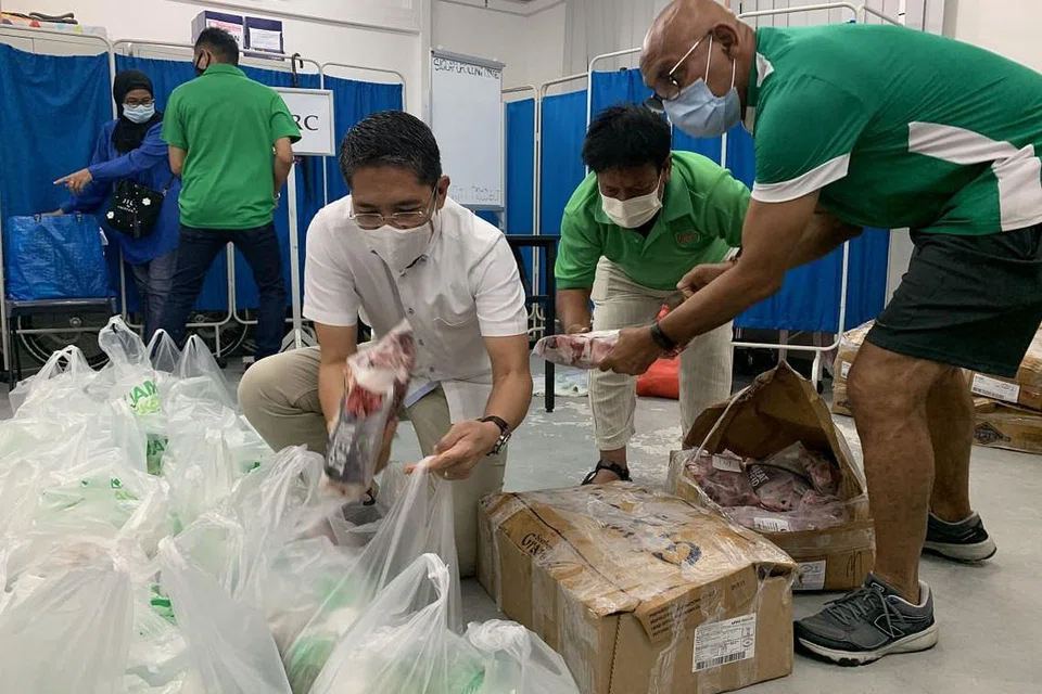 Dr Maliki membungkus pek 'Meat-for-Eid' sumbangan Jamiyah Singapura di Kelab Masyarakat Siglap pada Sabtu (8 Mei). 