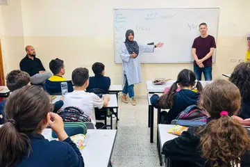 CURAH BAKTI: Cik Atikah Syarah Ismail (bertudung) dan rakan relawan mengajar kanak-kanak bahasa Inggeris dalam bilik darjah di Kem Pelarian Al-Fawwar, yang menempatkan pelarian Palestin di Hebron, Tebing Barat. 