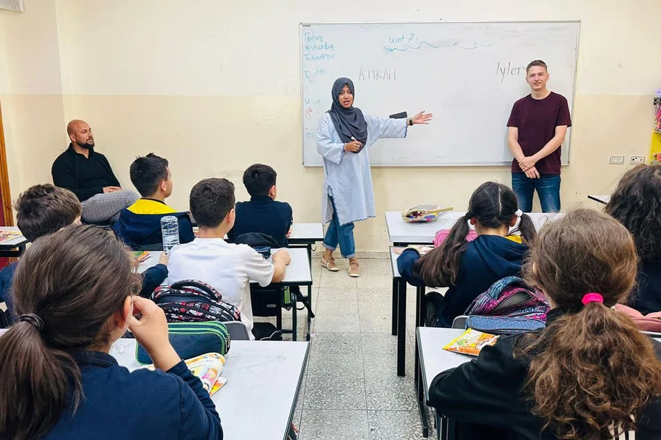 CURAH BAKTI: Cik Atikah Syarah Ismail (bertudung) dan rakan relawan mengajar kanak-kanak bahasa Inggeris dalam bilik darjah di Kem Pelarian Al-Fawwar, yang menempatkan pelarian Palestin di Hebron, Tebing Barat. 