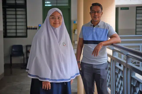 KEBANGGAAN BAPA: Nadiah (bersama bapanya, Encik Mohamed Rafi Mohamed), merupakan kumpulan pertama seramai 25 pelajar Madrasah Aljunied Al-Islamiah yang menduduki peperiksaan IBDP tahun lalu dan berjaya meraih keputusan yang amat memberangsangkan. - Foto BH oleh MARK CHEONG