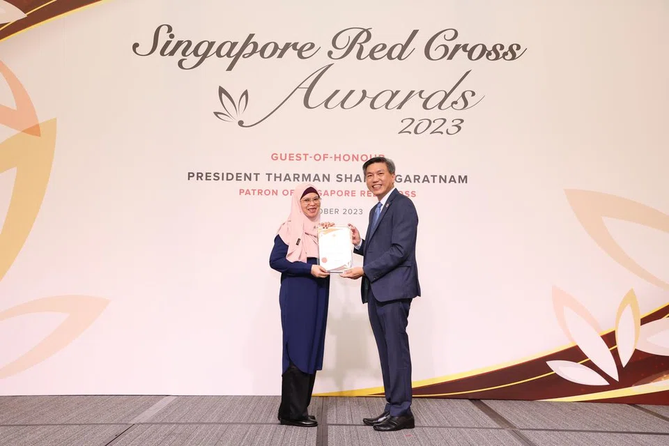 SUMBANGAN DIIKTIRAF: Masa dan tenaga yang dicurahkan Cik Sarbanun Ab Rahman, 55 tahun (kiri), sebagai pendamping perubatan kepada golongan warga emas diiktiraf dengan Anugerah Kepujian Palang Merah Singapura oleh pengerusi Palang Merah Singapura (SRC), Encik Tan Kai Hoe pada 3 Oktober.