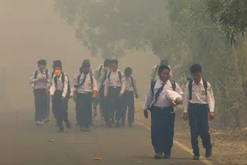 Sekumpulan murid sekolah berjalan di sebatang jalan yang diselubungi asap tebal di Tegal Arum, Banjarbaru, Kalimantan Selatan, pada 20 Oktober 2026, susulan kebakaran hutan dan tanah yang berlarutan. Menurut kajian Pusat Penyelidikan Tenaga dan Udara Bersih (CREA), pencemaran udara akibat kebakaran di Indonesia dianggarkan meragut 3,560 nyawa sepanjang September, manakala hampir 58 juta penduduk terdedah kepada udara pada tahap tidak sihat hingga berbahaya.