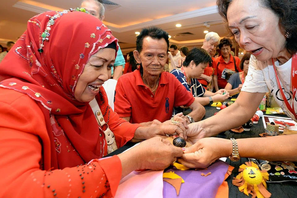 MENGHIAS BOLA GOLF: Cik Aminah Sulaiman (kiri) bersama suaminya, Encik Mohamed Ali, antara peserta yang meluangkan masa menghias bola golf untuk mengutip derma bagi program berkaitan kesihatan. - FOTO ZAINAL YAHYA