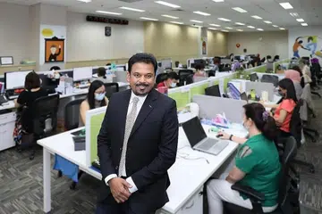 USAHA BERSAMA: (Gambar atas) Encik Abdul Aziz Yusof dengan para pekerjanya. - Foto CLEANING EXPRESS PTE LTD