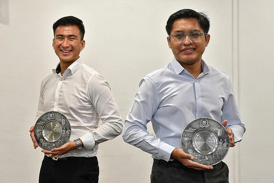 BANTU PEMANDU BAS YANG DIKASARI: Encik Clement Tan (kiri) dan Encik Muhammad Mu'tasim Kassim antara 10 orang yang diberi Anugerah Semangat Kemasyarakatan di Divisyen Polis Bedok semalam. - Foto BH oleh CHONG JUN LIANG