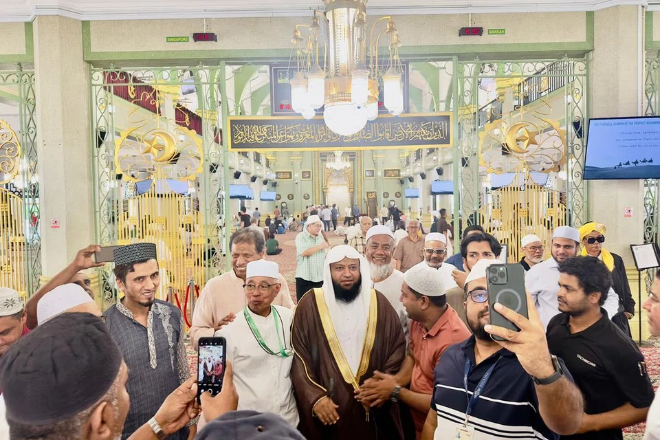 DEKATI ULAMA: Orang ramai bergambar bersama Sheikh Muhammad Saad Nomani Madani di Masjid Sultan pada Jumaat.