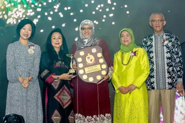 MENGIKTIRAF IBU TELADAN: (Dari kiri) Penasihat panel pengadil Anugerah Ibu Teladan, Cik Sim Ann, serta pengerusi Cik Claire Chiang, bersama penerima Anugerah Ibu Teladan, Cik Bibi Fatimah Sheikh Muhammad, dan Presiden Halimah Yacob dan suaminya, Encik Mohamed Abdullah Alhabshee. - Foto BH oleh ZALEHA ABDUL KADER