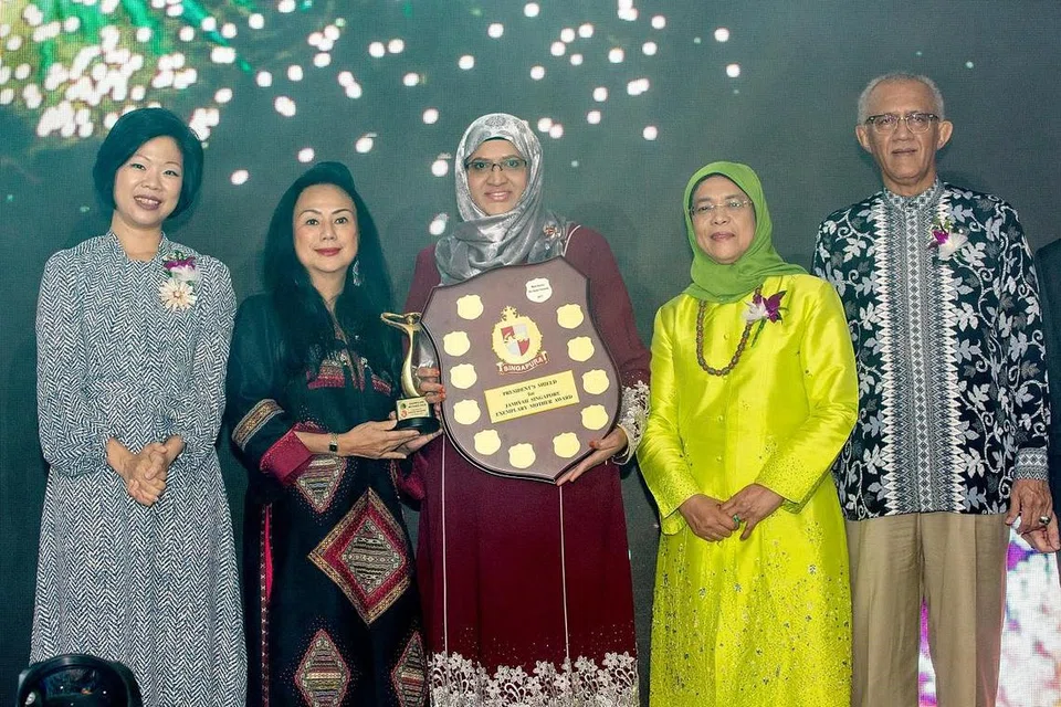 MENGIKTIRAF IBU TELADAN: (Dari kiri) Penasihat panel pengadil Anugerah Ibu Teladan, Cik Sim Ann, serta pengerusi Cik Claire Chiang, bersama penerima Anugerah Ibu Teladan, Cik Bibi Fatimah Sheikh Muhammad, dan Presiden Halimah Yacob dan suaminya, Encik Mohamed Abdullah Alhabshee. - Foto BH oleh ZALEHA ABDUL KADER