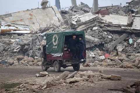SEMUA RUNTUH: Kanak-kanak ini menaiki kenderaan di tengah-tengah bangunan yang runtuh di bandar al-Rai town, utara Aleppo. - Foto REUTERS