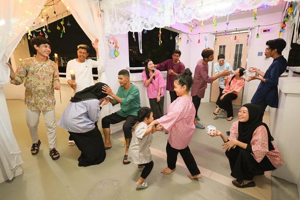 Encik Farid Difari (baju hijau) dan anggota keluarga bersalam-salaman dan bergambar dengan hiasan lampu lap-lip mereka bertemakan ala kampung bagi Aidilfitri 2024.