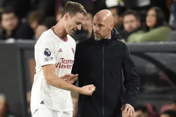 Jonny Evans (kiri) bersama jurulatih Manchester United, Erik ten Hag. Evans mengumumkan persaraannya daripada bola sepak antarabangsa setelah berkhidmat kepada negaranya sejak 2006 ketika masih berusia 18 tahun. 