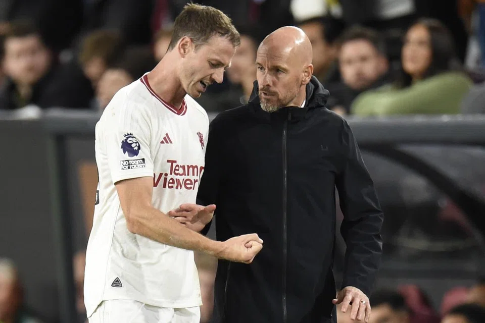 Jonny Evans (kiri) bersama jurulatih Manchester United, Erik ten Hag. Evans mengumumkan persaraannya daripada bola sepak antarabangsa setelah berkhidmat kepada negaranya sejak 2006 ketika masih berusia 18 tahun. 