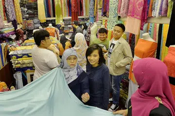 SIBUK BELI KAIN: Para pembeli di Aladdin's Exclusive di Arab Street sibuk membeli kain untuk dibuat baju Raya. - Foto ZAINAL YAHYA