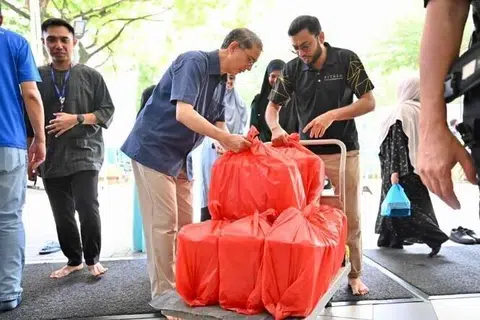 Profesor Madya Dr Muhammad Faishal Ibrahim (dua dari kiri), menerima hidangan nasi beriani yang akan diagihkan kepada sekitar 460 benefisiari, terdiri daripada bekas banduan dan mereka yang terjejas akibat penyalahgunaan dadah, pada Jun lalu.