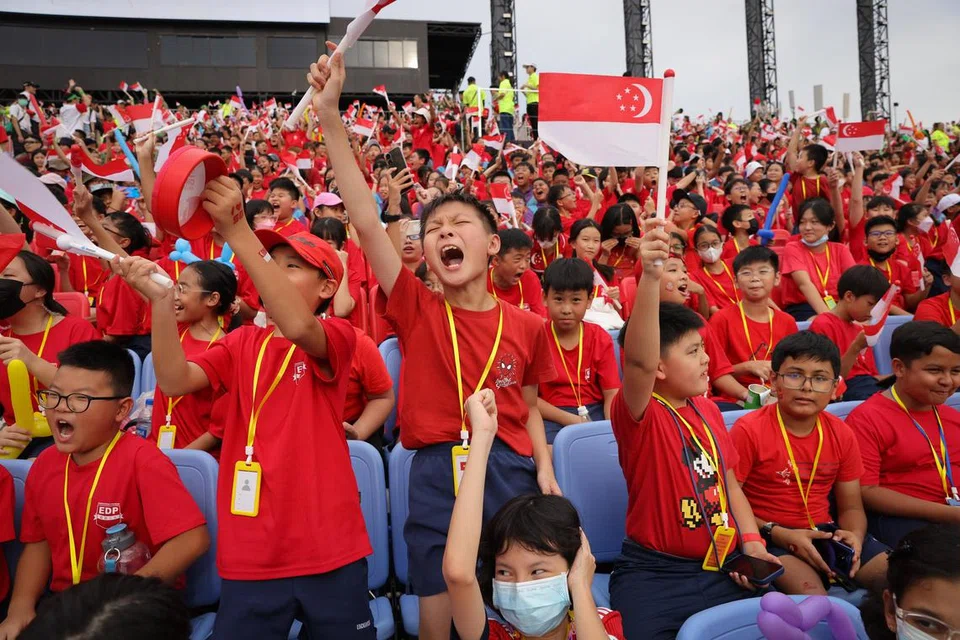 MERDEKA: Para pelajar bersemangat menyaksikan perbarisan Hari Kebangsaan.