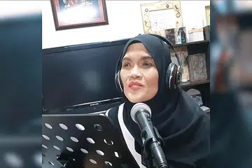 TAJAMKAN VOKAL: Datuk Wan Aishah Wan Ariffin mengasah kemahiran menyanyi lagu 'cover'. - Foto TANGKAP SKRIN YOUTUBE AISHAH JMM OFFICIAL