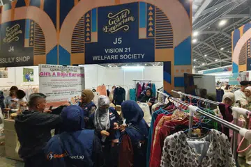 HADIAH BAJU BARU: Vision 21 mengedarkan baju Raya kepada keluarga kurang bernasib baik yang hadir dalam majlis iftar besar-besaran di Dewan 5 Singapore Expo.