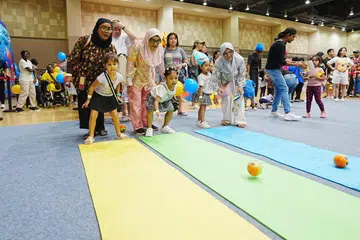 Cik Anhkashah Khamis (kanan) dan kakaknya, Cik Anhdauwiyah Khamis (kiri) menyertai acara KidSTART PlayDate yang diadakan di Our Tampines Hub pada 4 Ogos bersama (tengah) ibu mereka, Cik Jamaliah Ahmad, dan anak-anak mereka (dari kiri), Maija Jade Queara Aspelin, Nur Aaliesya Levienia dan Nur Aryyanna Qaysara.