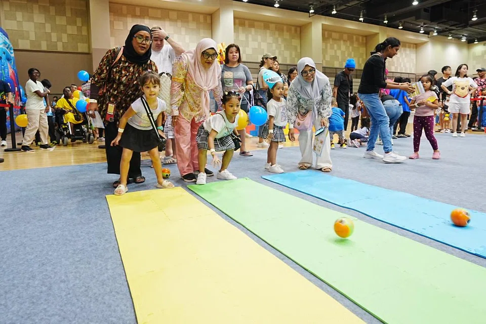 Cik Anhkashah Khamis (kanan) dan kakaknya, Cik Anhdauwiyah Khamis (kiri) menyertai acara KidSTART PlayDate yang diadakan di Our Tampines Hub pada 4 Ogos bersama (tengah) ibu mereka, Cik Jamaliah Ahmad, dan anak-anak mereka (dari kiri), Maija Jade Queara Aspelin, Nur Aaliesya Levienia dan Nur Aryyanna Qaysara.