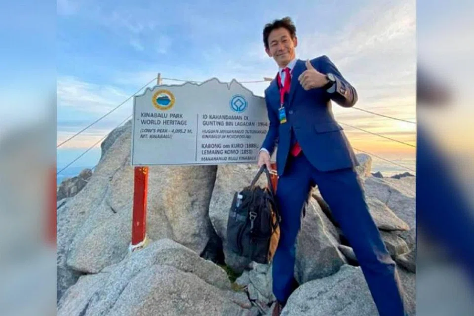 LUAR KEBIASAAN: Encik Nobutaka Sada bergambar di puncak Gunung Kinabalu berpakaian rasmi biru-kebiruan dan membawa sebuah beg galas. - Foto FACEBOOK/ NOBUTAKA SADA