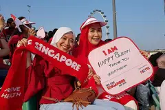GHAIRAH TONTON SECARA LANGSUNG: Cik Lynn (kanan) dan anaknya, Cik Erna Adlina, begitu bersemangat menonton previu pertama NDP 2018. Mereka tiba di Platform Terapung Marina Bay sebelum 4.30 petang meskipun cuaca panas terik Sabtu lalu. - Foto ihsan LYNN SIREGAR