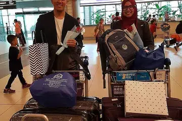 RAIH TEMPAT LIMA TERBAIK: Qari dan qariah Singapura, Ustaz Nor Muhammad Ali dan Ustazah Atiiqah Suhaimi ketika tiba di Lapangan Terbang Changi semalam. Mereka masing-masing mendapat tempat kelima dan ketiga dalam Majlis Tilawah Menghafaz Al Quran Peringkat Antarabangsa ke-59 di Kuala Lumpur. - Foto ihsan NURUL IZZAH KHAMSANI
