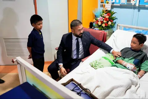 Pemangku Sultan Johor, Tunku Mahkota Ismail Sultan Ibrahim, bersama anaknya Raja Muda Johor, Tunku Iskandar Tunku Ismail (kiri), ketika melawat mangsa, Izzul Islam Azuan Isaidi.