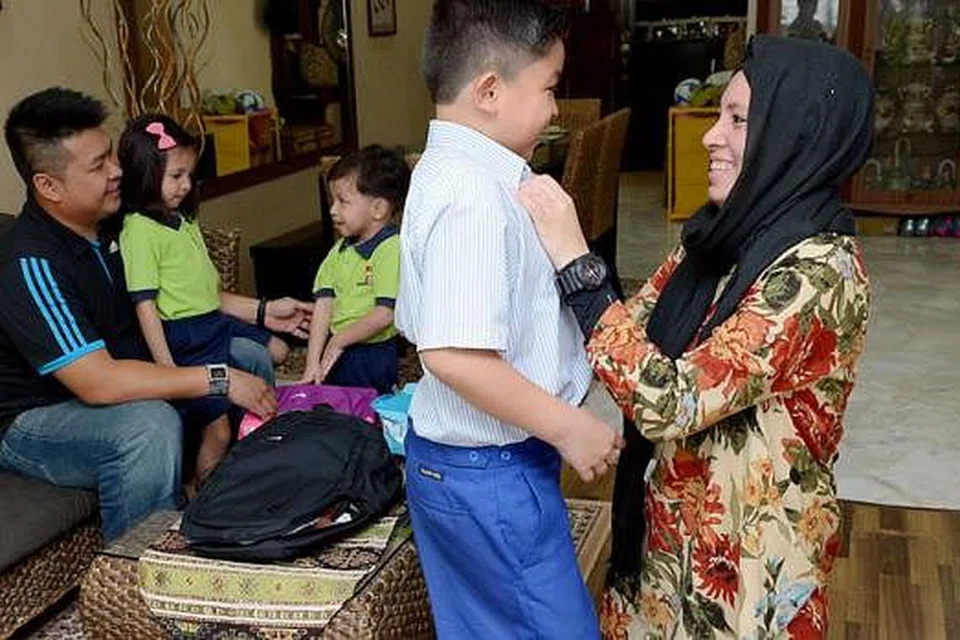 SIAP SEDIA HADAPI HARI PERTAMA KE SEKOLAH: Cik Norazlindah (kanan) dan suami, Encik Mohd Izwan (kiri) telah memulakan persediaan sekolah untuk anak-anak mereka, (dari kanan) Irfan, Irwan dan Nur Sarah, sejak dua minggu lalu. - Foto TUKIMAN WARJI