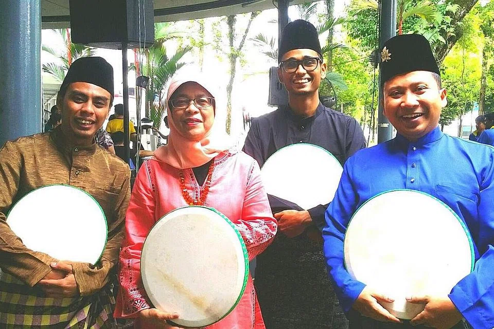 BERSAMA PRESIDEN HALIMAH: Pengasas Kompanghut, Encik Hazre Salim (kanan) dan ahli-ahli Kompanghut bergambar bersama Presiden Halimah Yacob di Pusat Komuniti (CC) Marsiling. - Foto KOMPANGHUT