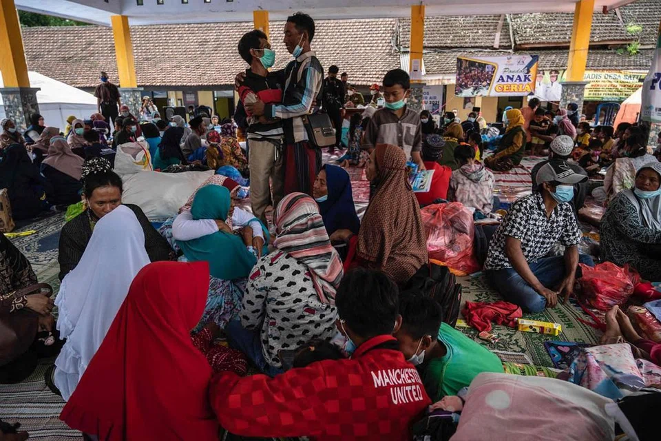 TEMPAT BERTEDUH: Penduduk terpaksa mencari tempat berteduh sementara yang selamat di kawasan kampung Sumber Wuluh di Lumajang selepas rumah mereka rosak. - Foto AFP