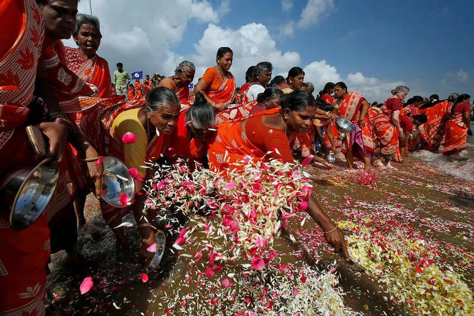 Para wanita menaburkan kelopak bunga ke dalam lautan di Bay of Bengal sebagai memperingati mangsa tsunami yang berlaku 15 tahun lalu di Chennai. FOTO: REUTERS