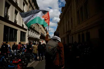 Pelajar memegang bendera Palestin ketika mereka berkumpul berhampiran Universiti Sorbonne di Perancis untuk menyokong rakyat Palestin di Gaza sedang pasukan polis antirusuhan Perancis menghalang tunjuk perasaan berunsur perpaduan dengan penduduk Gaza pada 29 April.
