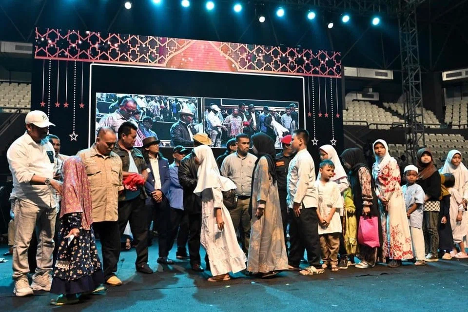 Sebilangan anak yatim menerima bantuan semasa acara yang diadakan oleh bakal presiden, Encik Prabowo Subianto, dan bakal naib presiden, Encik Gibran Rakabuming Raka, di Stadium Tertutup Tenis Senayan, di Jakarta.  