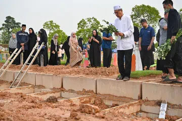 Encik Mohamed Kassim Yusoff, datuk kepada Allahyarhamha Afifah Munirah Muhammad Azril (gambar sisipan), beri penghormatan terakhir kepada cucunya setelah dikebumikan di Pusara Aman pada 23 April. 