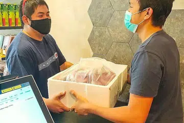 KERJA BARU: Encik Fazli Azman (kiri), 27 tahun, seorang pemandu kereta sewa privet juga bertugas sebagai penghantar, setelah menyertai inisiatif Delivery Hero. - Foto THE MEATERY