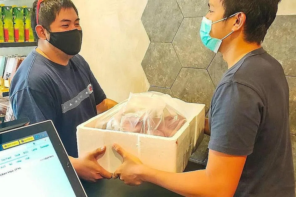 KERJA BARU: Encik Fazli Azman (kiri), 27 tahun, seorang pemandu kereta sewa privet juga bertugas sebagai penghantar, setelah menyertai inisiatif Delivery Hero. - Foto THE MEATERY