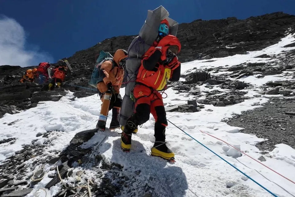 LAKUKAN USAHA MENYELAMAT: Encik Nima Tahi Sherpa  berjalan sambil membawa pendaki Malaysia semasa menyelamatkannya daripada ‘zon maut’ berdekatan puncak Gunung Everest. 