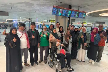 Cik Maimunah (enam dari kanan, bertudung hitam) bersama rakan-rakannya tiba di Singapura pada 9 Mei setelah menempuh perjalanan darat 24 jam dari Srinagar, Kashmir, ke New Delhi, semata-mata untuk menaiki pesawat dan pulang ke Singapura