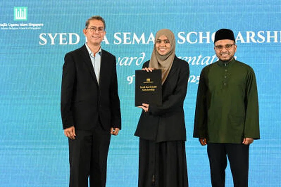Cik Nusaybah Muhammad Iqbaal daripada Madrasah Aljunied Al-Islamiah menerima Biasiswa Syed Isa Semait (SISS) daripada Pemangku Menteri Bertanggungjawab bagi Ehwal Masyarakat Islam, Profesor Madya Dr Muhammad Faishal Ibrahim (kiri), dan Mufti Dr Nazirudin Mohd Nasir, semasa majlis penyampaian Biasiswa SISS dan Majlis Ugama Islam Singapura (Muis) di Pusat Konvensyen dan Pameran Suntec Singapura pada 9 Julai.