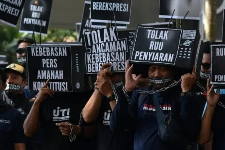 Anggota Persatuan Wartawan Televisyen Indonesia (IJTI), dengan wajah ditutup kotak hitam tertulis “kebebasan media adalah mandat perlembagaan” dan pergelangan tangan dirantai bersama, mengadakan demonstrasi pada 17 Mei 2024 di hadapan Dewan Perwakilan Rakyat Daerah (DPRD) Blitar, wilayah pentadbiran Jawa Timur.
