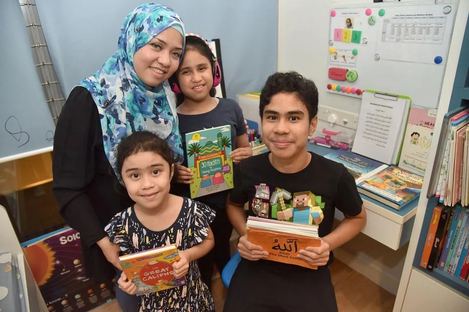 MENDIDIK ANAK AUTISME: Cik Noreen (bertudung biru), mempunyai dua anak autisme - Irfan (berdiri di depan) dan Natasha (memakai headphone). Anak bongsunya, Sofea (di kanan Irfan) tidak mengalami masalah autisme. - Foto BH oleh JASMINE CHOON