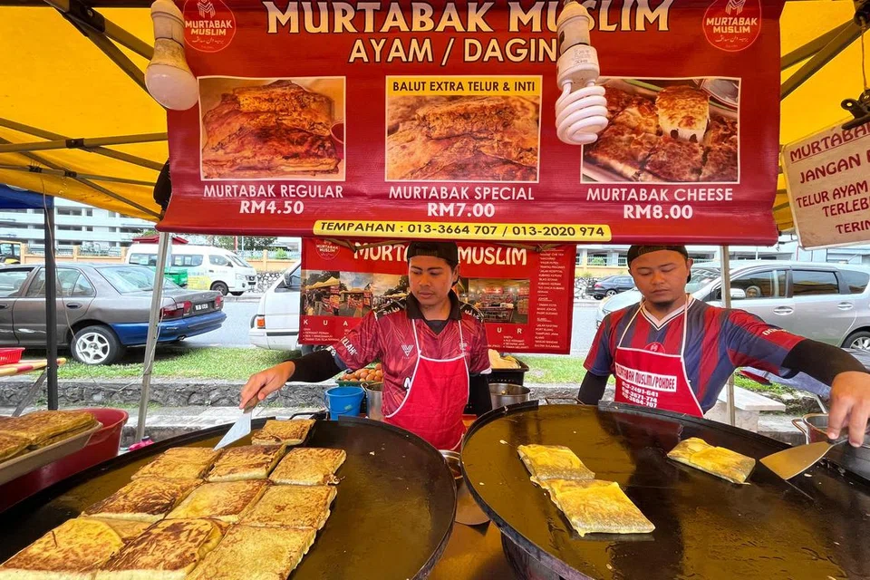 Peniaga Encik Mohamad Nasrul Ruszalani, 24 tahun (kiri), dan abangnya, Muhammad Nasrin, 27 tahun, sudah lebih lima tahun berniaga martabak Muslim di bazar Ramadan Bandar Baru Ampang di Selangor. Bazar di bawah seliaan Majlis Perbandaran Ampang Jaya ini buat kali pertama beroperasi lebih awal iaitu bermula 27 Februari.