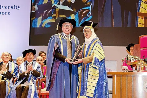 SUMBANGAN MELUAS: Presiden Halimah Yacob yang juga Canselor NUS telah menganugerahkan Doktor Kehormat kepada pengasas dan CEO Ho Bee Group, Encik Chua Thian Poh, atas sumbanganya kepada masyarakat serta kemajuannya dalam meraih ilmu dan pengetahuan, yang telah memberi manfaat kepada Singapura. - Foto CMG