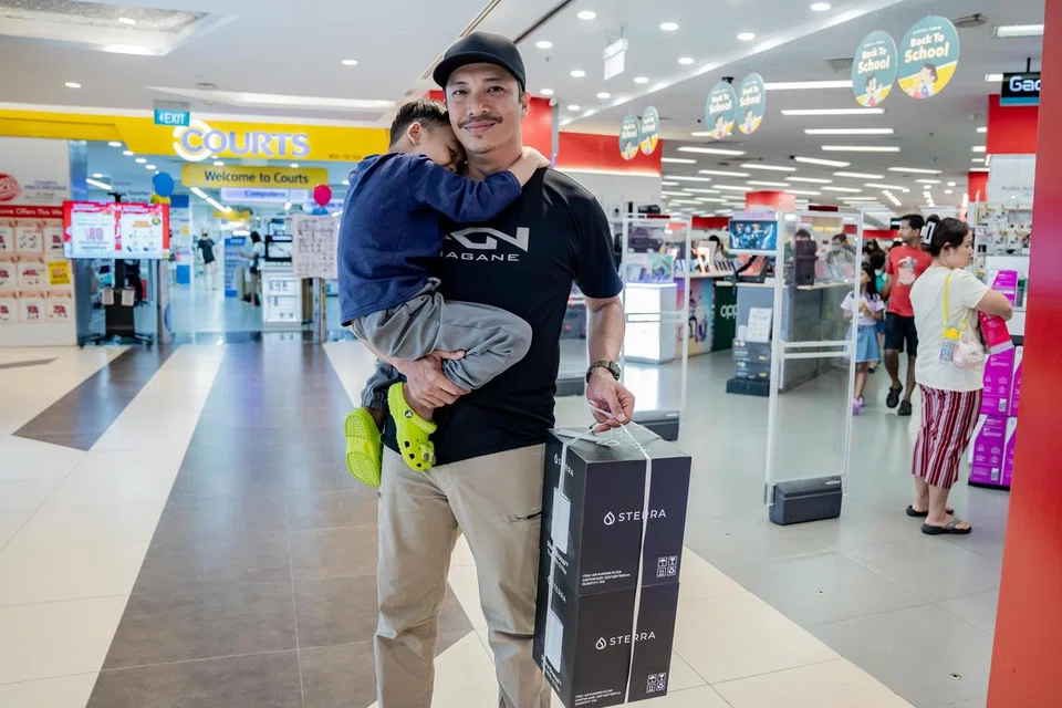 CERMAT BERBELANJA: Encik Mohammed Ghazali, 41 tahun dan bapa kepada tiga anak juga antara pembeli di Tampines Mall yang mendapatkan keperluan sekolah untuk tiga anaknya dan menekankan pentingnya bertindak dengan lebih cermat dalam membuat keputusan pembelian memandangkan kenaikan GST pada 2024. 