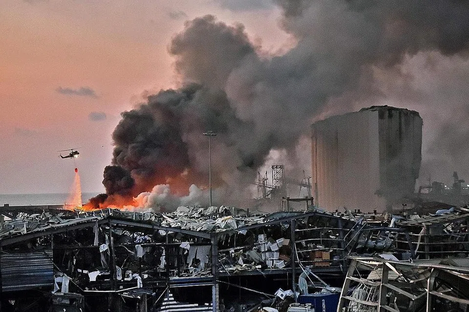 LETUPAN: Sebuah helikopter kelihatan memadamkan kebakaran di lokasi letupan di pelabuhan Beirut di ibu negara Lebanon pada 4 Ogos. Pihak berkuasa Lebanon berkata letupan itu dipercayai berpunca daripada 2,750 tan ammonia nitrat yang disimpan secara cuai di gudang dekat Pelabuhan Beirut sejak 2013. Tragedi itu mengorbankan hampir 150 orang, manakala sekurang-kurangnya 5,000 mangsa cedera dan keseluruhan daerah dan bandar musnah. - Foto AFP