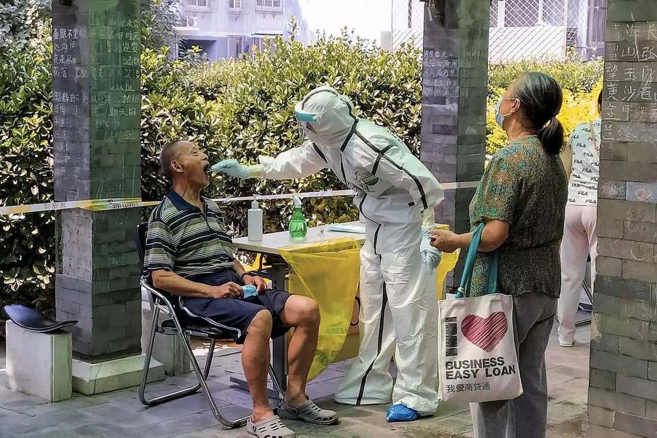 CHINA: Seorang lelaki menjalani pemeriksaan asid nucleic di pusat pemeriksaan. China melaporkan semalam 26 kes baru bagi kelmarin, turun daripada 27 kes pada hari sebelumnya. - Foto REUTERS 