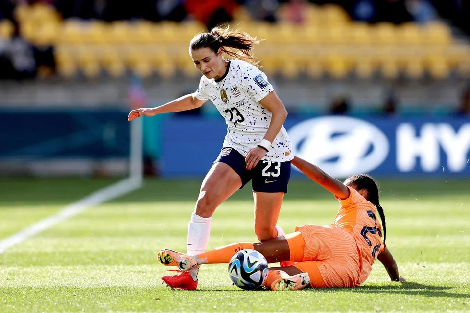 PERSAINGAN SENGIT: Pemain Amerika Syarikat Emily Ann Fox (kiri) melepaskan diri daripada terkaman pemain Belanda Kristen Anne Mewis semasa perlawanan Piala Dunia Wanita di New Zealand. 