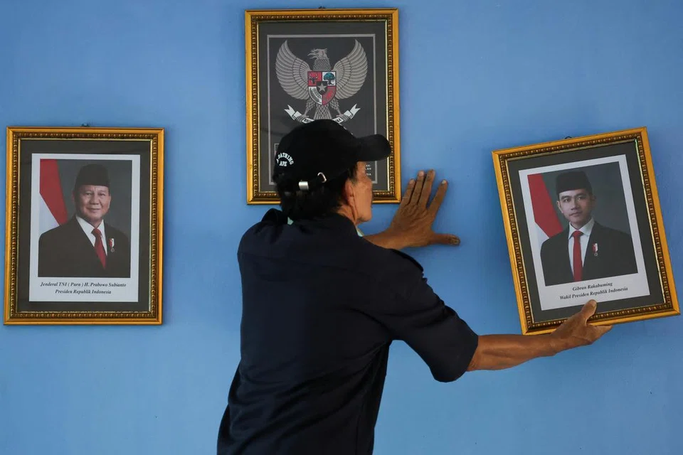 Seorang pekerja memegang potret Naib Presiden baru Indonesia, Encik Gibran Rakabuming Raka, selepas menggantikan potret mantan Naib Presiden Encik Ma’ruf Amin di sebuah sekolah rendah Pagi Pondok Labu, di Jakarta, Indonesia, pada 22 Oktober 2024