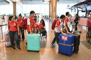 SEMBANGAT BERKOBAR: Atlit para negara berkumpul di Lapangan Terbang Changi dan bersiap sedia untuk berangkat ke Jakarta. - Foto BH oleh KHALID BABA